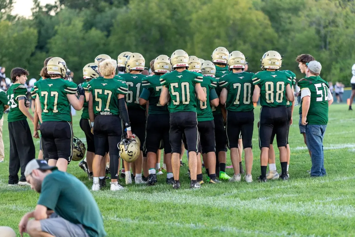 Sussex Tech Mustangs football players gathered together in a team huddle